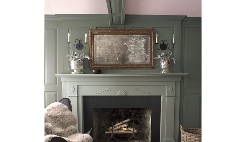 Paredes pintadas de verde oliva con un techo pintado de rosa claro y una chimenea de color verde.